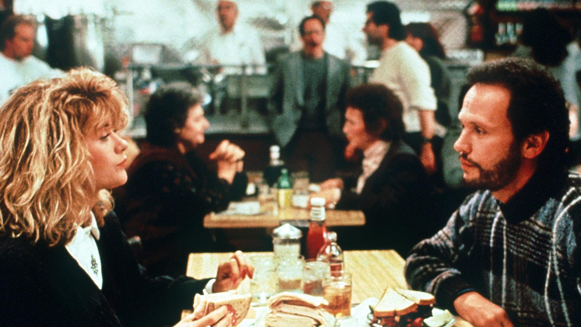 Harry Burns (Billy Crystal) sitzt im Filmklassiker "Harry und Sally" von 1989 Sally Albright (Meg Ryan) im Restaurant gegenüber.