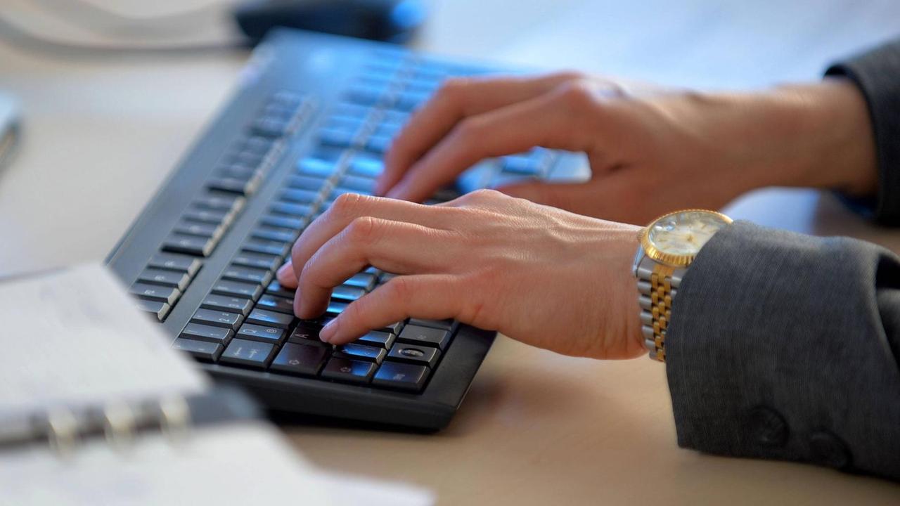 Eine Frau arbeitet an einer Computer-Tastatur.