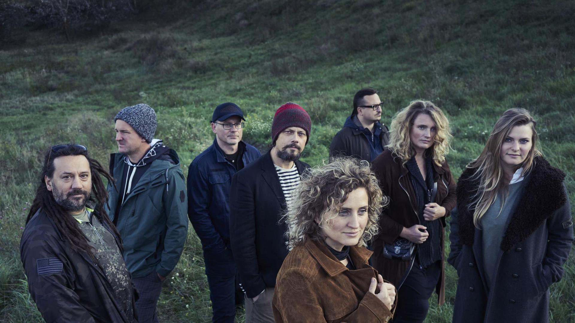 Dei acht Bandmitglieder von "Warsaw Village Band" stehen in den wilden Hügeln von Masowien.