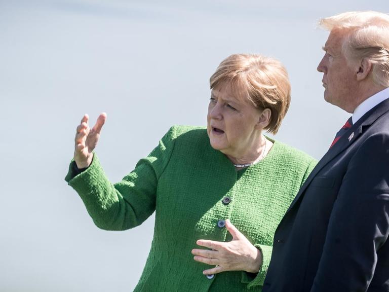Bundeskanzlerin Angela Merkel (CDU) spricht mit Donald Trump, Präsident der USA, nach dem Familienfoto.