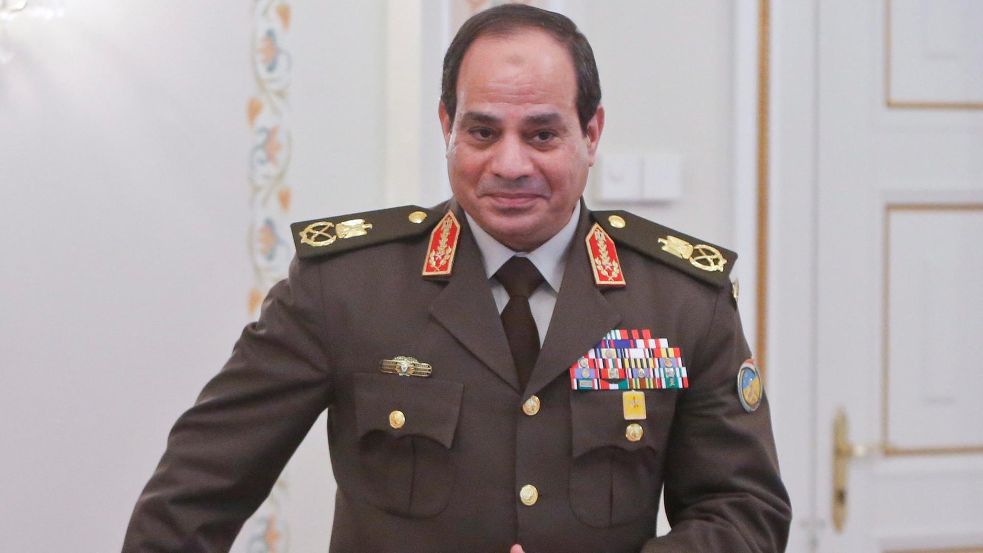 Abdel Fattah al-Sisi lächelt bei einem Besuch im Kreml in die Kamera von Journalisten.