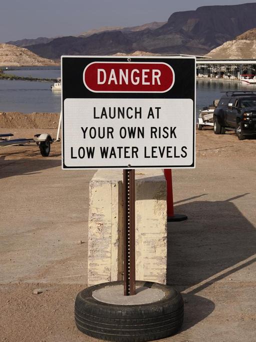Ein Schild warnt vor niedrigen Wasserstände an einer Bootsanlegestelle am Lake Mead am Colorado River, Nevada, USA.