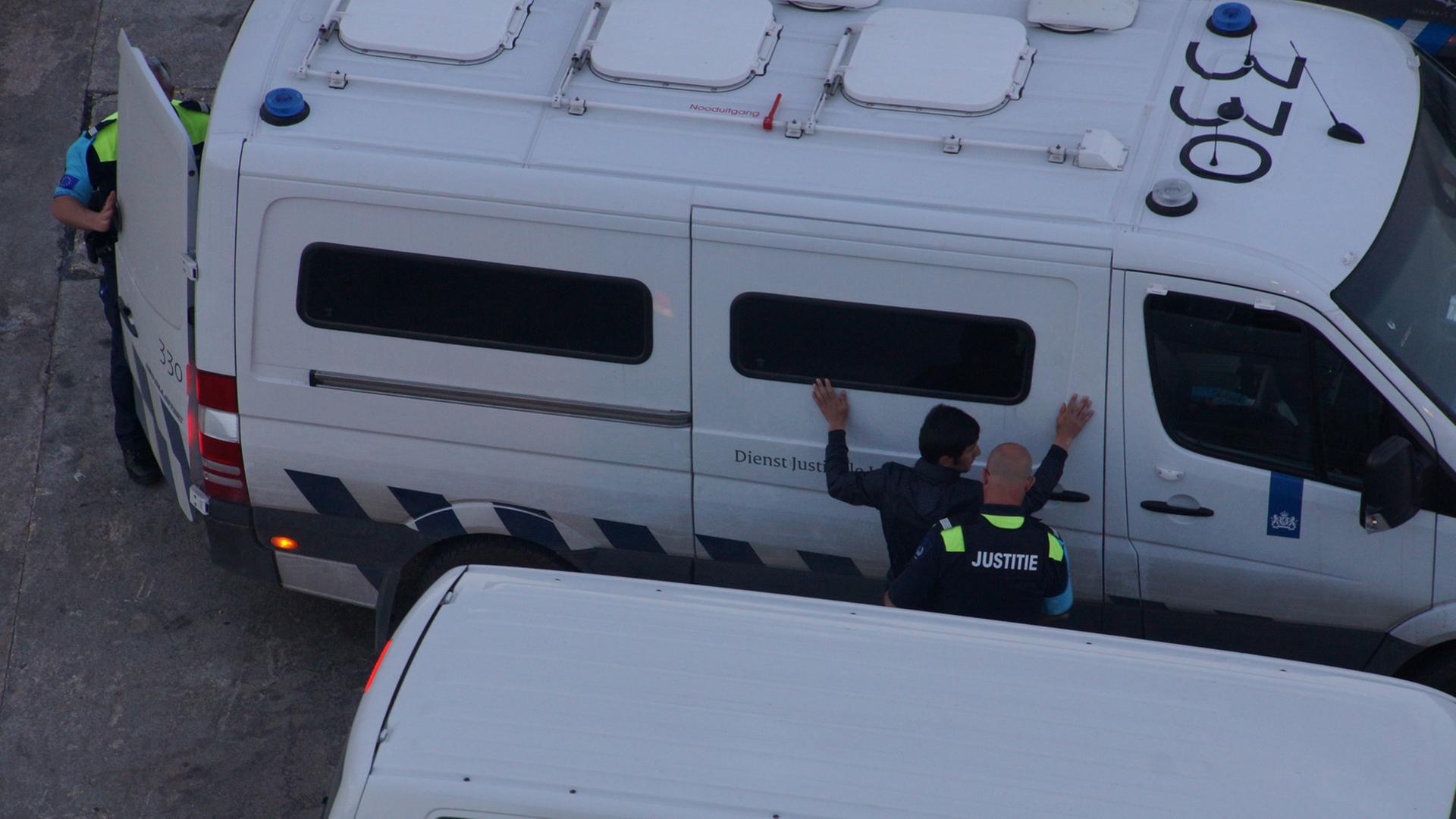 Frontex-Mitarbeiter nehmen einen Flüchtling fest.