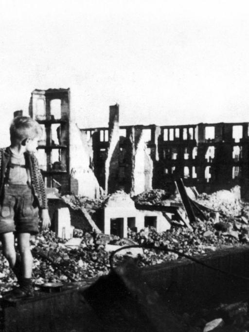 Ein kleiner Junge zwischen Trümmern und Hausruinen in Hamburg. Aufnahme von 1946.