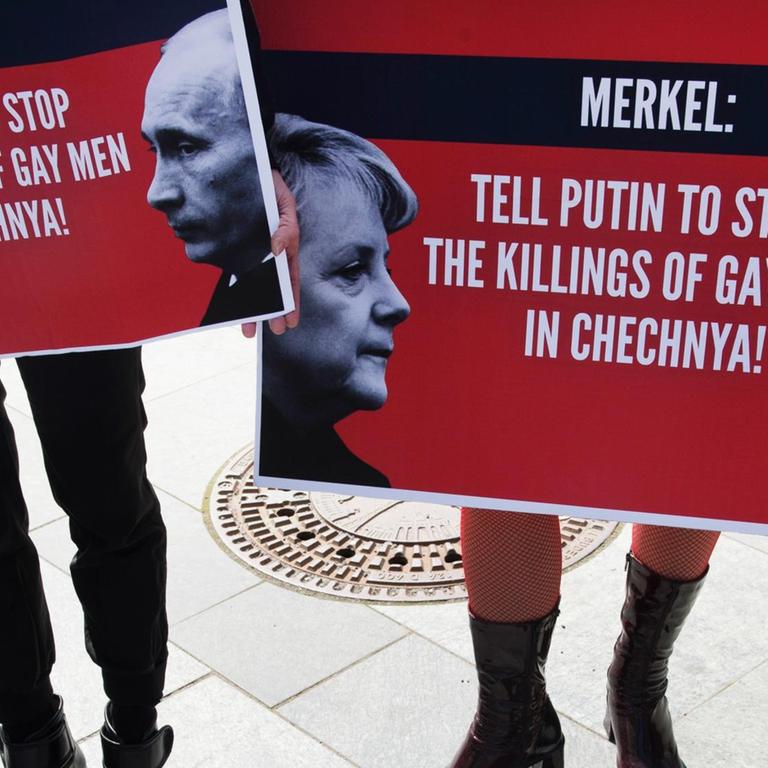 Demonstranten halten am 30.04.2017 in Berlin beim Start einer dreitägigen Mahnwache zum Schutz von Schwulen in Tschetschenien Plakate mit der Aufschrift "Merkel: Tell Putin to Stop the Killings of Gay Men in Chechnya" in den Händen.