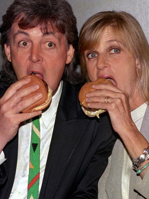 Paul und Linda McCartney posieren für ein Pressefoto und beißen herzhaft in einen vegetarischen Burger.