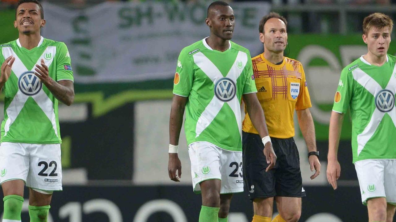 Die Wolfsburger Spieler Luiz Luiz Gustavo, Josuha Guilavogui und Robin Knoche laufen bei der 1:4-Niederlage im Europaleague-Viertelfinale gegen den SSC Neapel enttäuscht über den Rasen, hinter ihnen geht der Schiedsrichter.