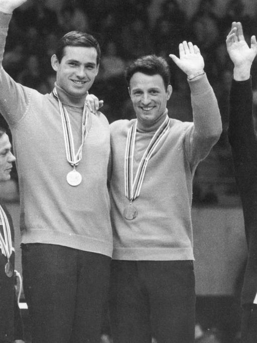 Der schnellste Doppelsitzer der Olympischen Winterspiele in Grenoble wird am 18.02.1968 im Eispalast der Stadt mit der Goldmedaille geehrt: Das DDR-Rodel-Duo Thomas Köhler (4.v.l.) und Klaus Bonsack (3.v.l) sichert sich die Goldmedaille vor den Österreichern Manfred Schmid, Ewald Walch (l) und den bundesdeutschen Rennrodlern Wolfgang Winkler/Fritz Nachmann (r)