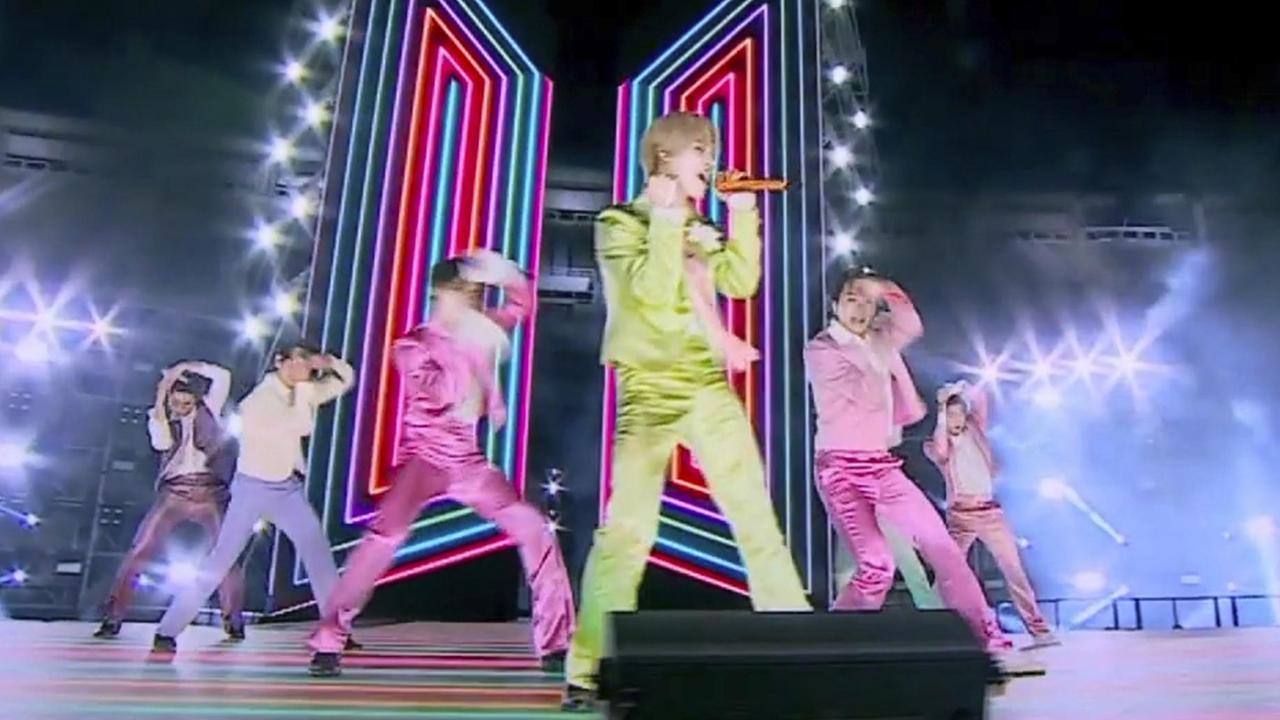 Die Mitglieder der K-Pop-Band BTS tanzen in pastellfarbenen Anzügen auf einer Bühne. Die Mitglieder der K-Pop-Band BTS tanzen in pastellfarbenen Anzügen auf einer Bühne.