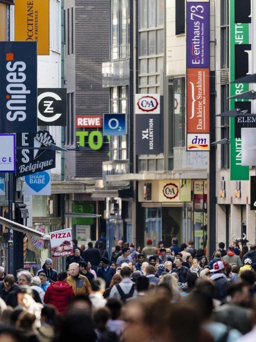 Passanten auf der Hohe Straße in Köln, im Hintergrund sind die Schilder vieler Geschäfte zu sehen, aufgenommen im Mai 2018.