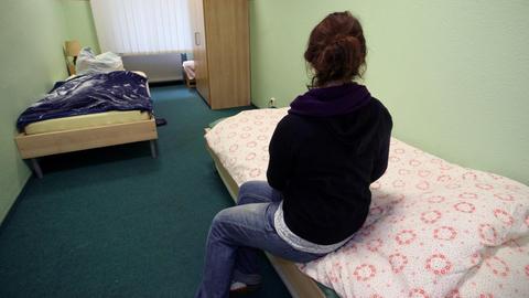 Eine Frau sitzt in einem Zimmer der "Notübernachtung für Frauen" am Donnerstag (11.12.2008) in Berlin beim Tag der offenen Tür auf ihrem Bett.