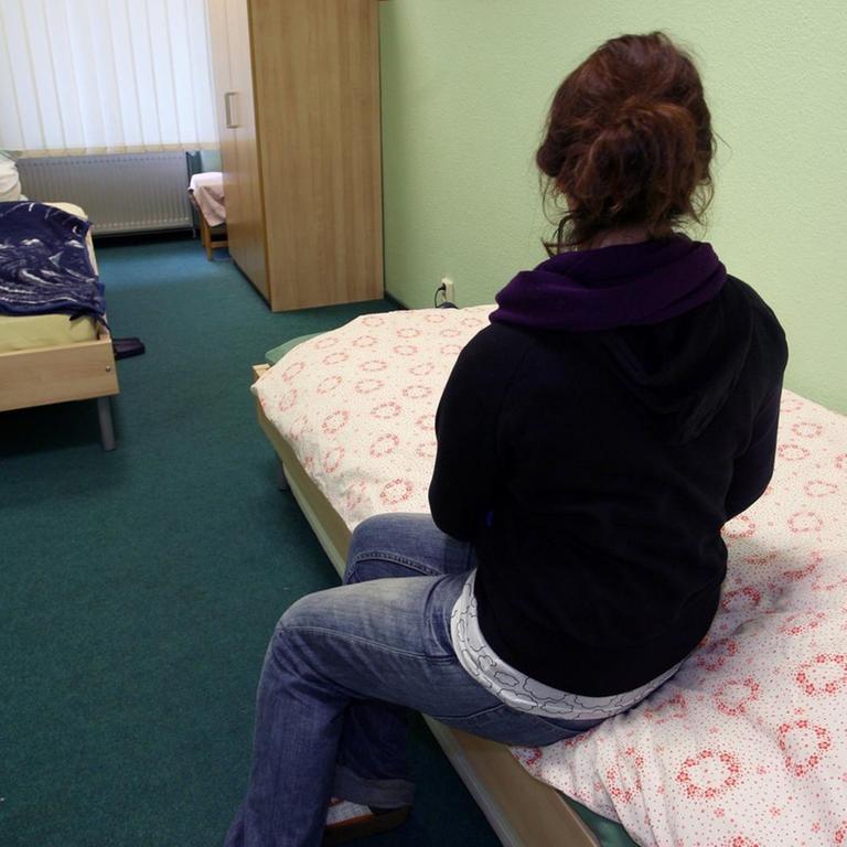 Eine Frau sitzt in einem Zimmer der "Notübernachtung für Frauen" am Donnerstag (11.12.2008) in Berlin beim Tag der offenen Tür auf ihrem Bett.