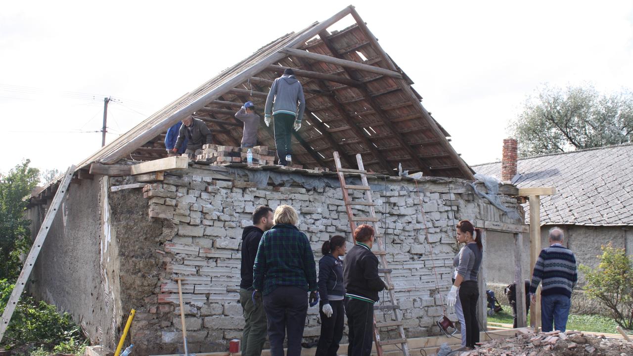 Roma in Felsödobsza reparieren ihre Häuser mit der Unterstützung durch freiwillige deutsche Handwerker.