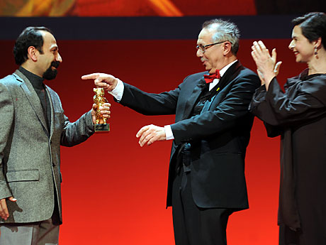 Der iranische Regisseur Asghar Farhadi (links) erhält aus der Hand von Berlinale-Leiter Dieter Kosslick den Goldenen Bären für seine Film "Nader und Simin, eine Trennung". Jury-Präsidentin Isabella Rossellini schaut zu.