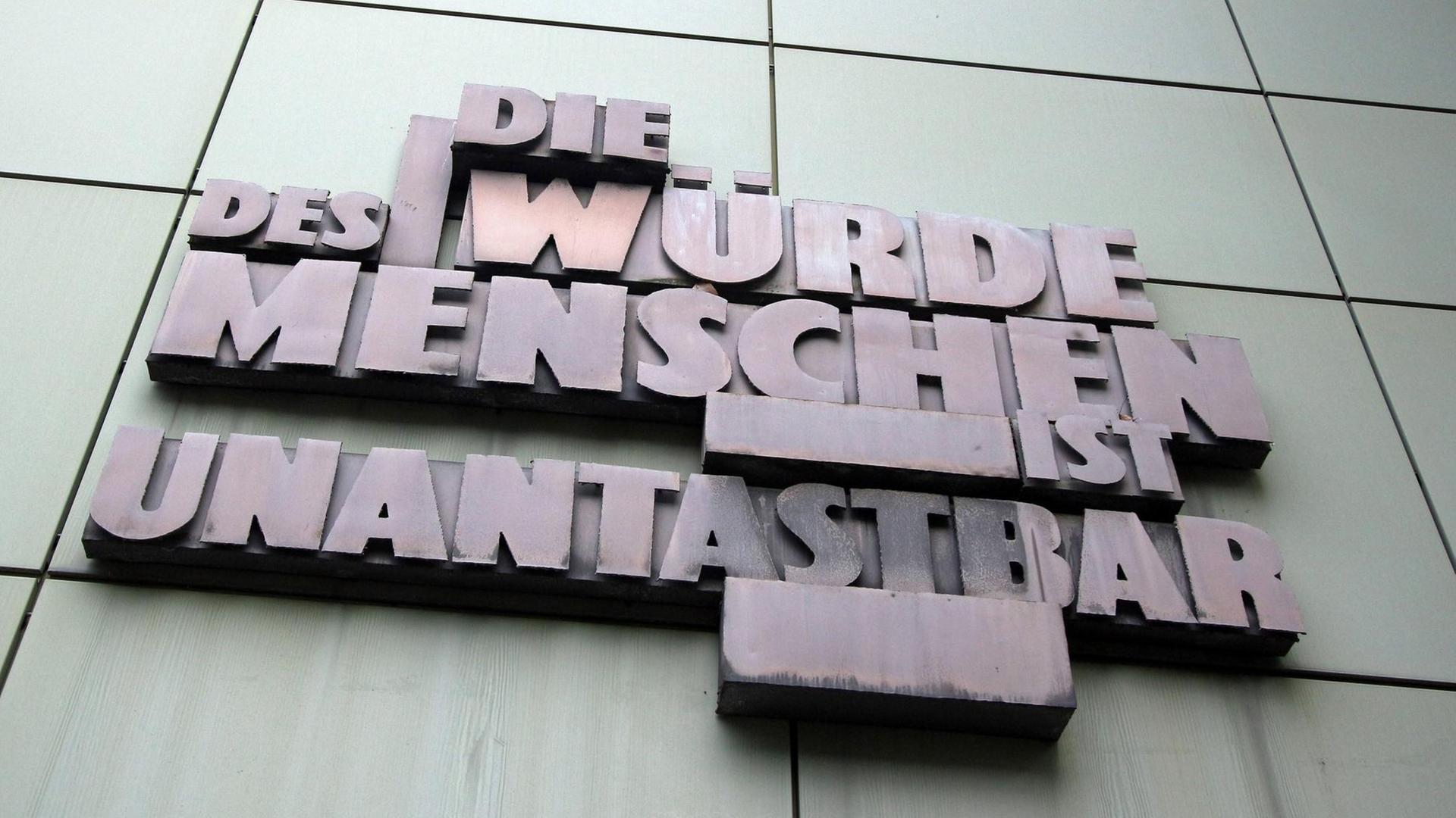 Skulptur mit Artikel 1 des deutschen Grundgesetzes "Die Würde des Menschen ist unantastbar" an der Fassade der Staatsanwaltschaft im Justizzentrum in der Innenstadt Frankfurt.