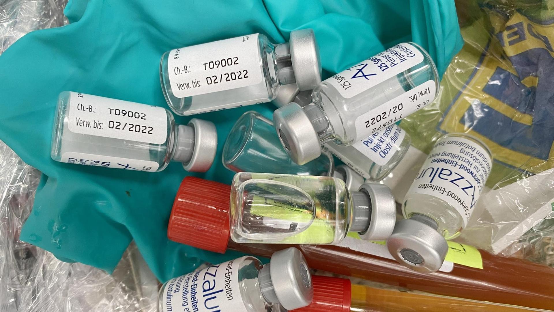Mehrere Fläschchen mit Corona-Impfstoffen liegen auf einem Haufen.