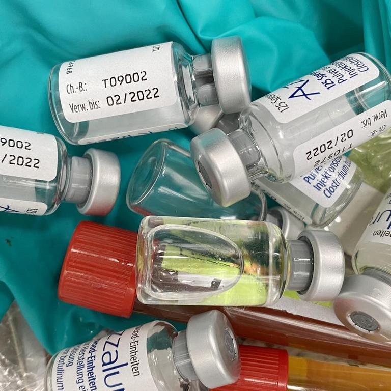 Mehrere Fläschchen mit Corona-Impfstoffen liegen auf einem Haufen.