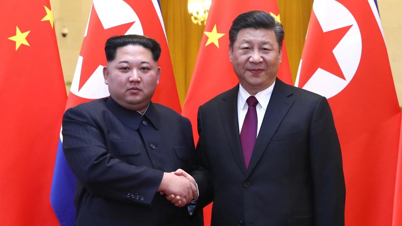 Nordkoreas Machthaber Kim Jong Un (l) und Chinas Präsident Xi Jinping sich die Hand gebend