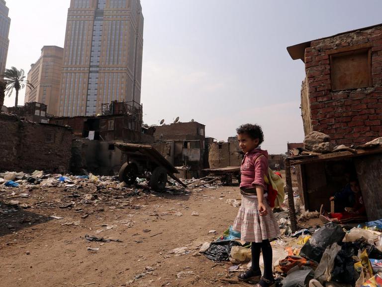 Ein Mädchen steht zwischen Müll in einem Slum vor Kairo.