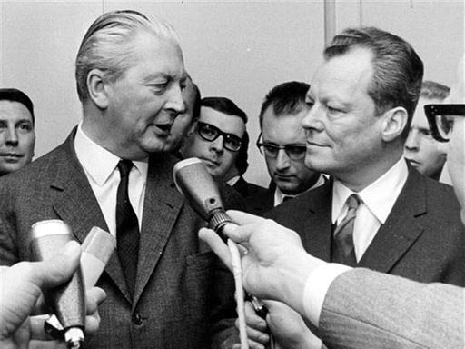 Kurt Georg Kiesinger, links, und Willy Brandt, rechts, geben Journalisten am 26. November 1966 Auskunft über die Große Koalition.