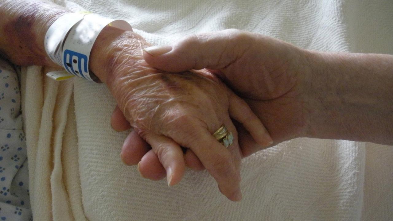 Hände von älteren Menschen, die sich trösten