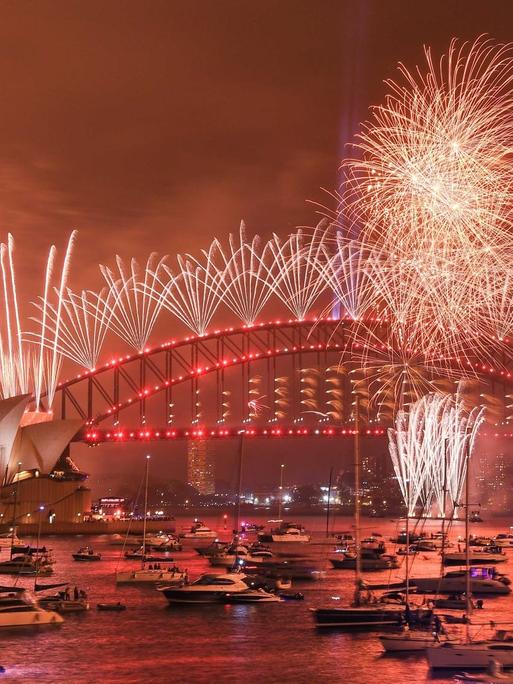 Nächtlicher Blick auf den Hafen und die Oper von Sydney mit großem Feuerwerk.