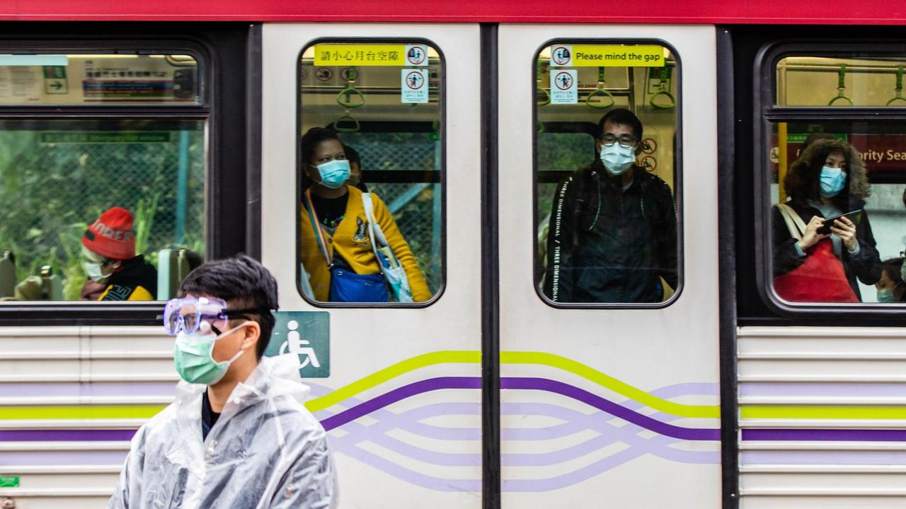 Fahrgäste einer Straßenbahn in Hongkong tragen Atemschutzmasken