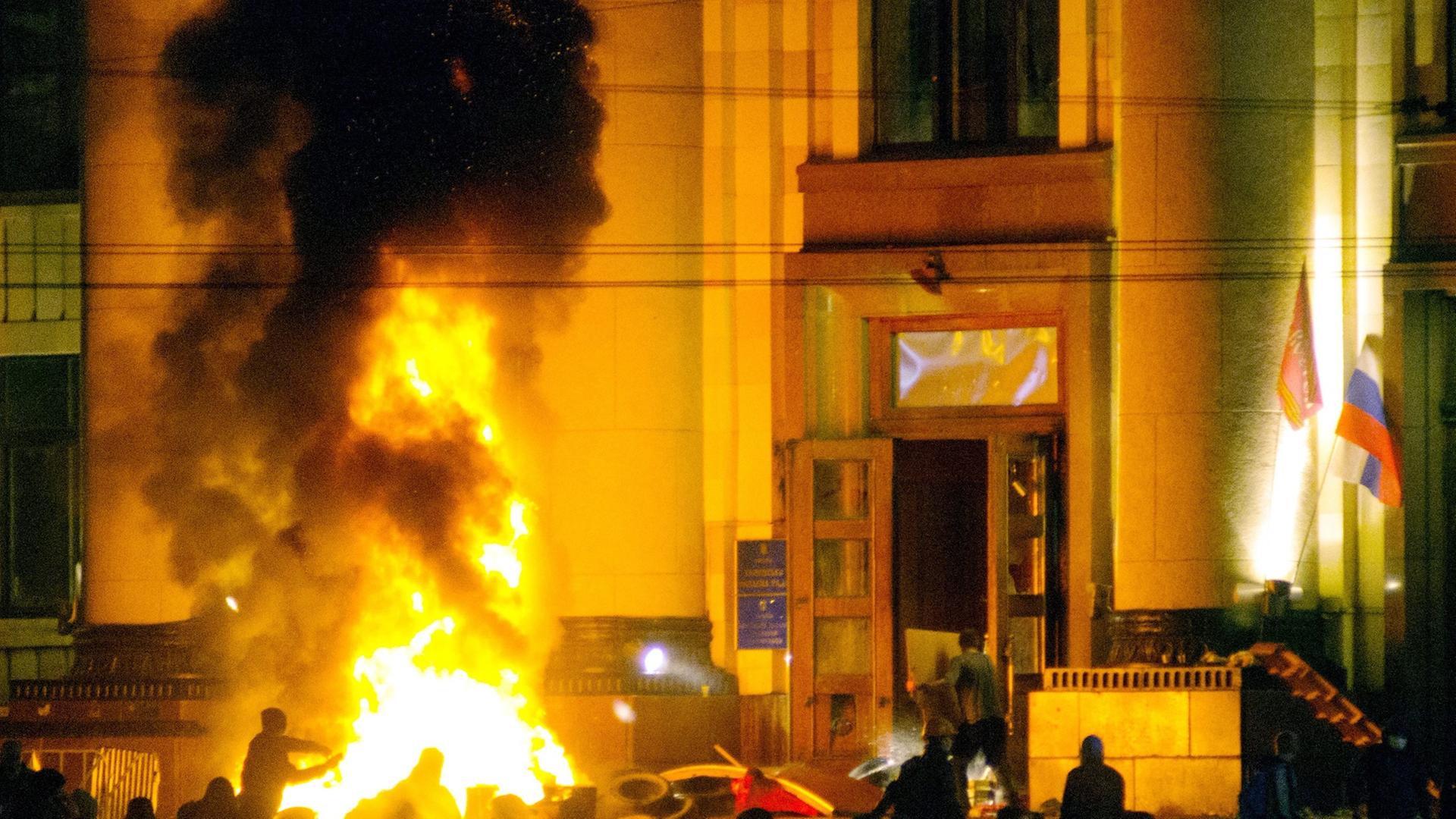 epa04158550 Pro-Russian protesters burn tires near of a regional administration building after police cleared it in Kharkiv, Ukraine, 07 April 2014. According to reports, pro-Russian demonstrators seized the administration building in Kharkiv at 06 April 