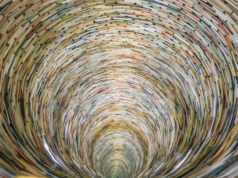 Die Installation "Idiom" von Matej Krén in der Prager Stadtbibliothek, bestehend aus Hunderten von Büchern, die zu einem zylindrischen Turm gestapelt sind.
