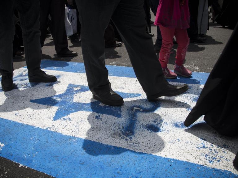 Iraner laufen über die israelische Flagge.