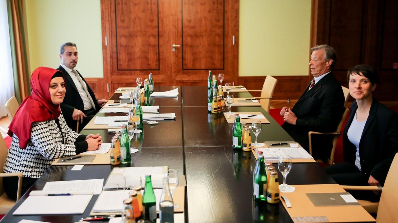 Die AfD-Vorsitzende Frauke Petry (r) und Armin Paul Hampel, Landesvorsitzender der AfD in Niedersachsen, nehmen gegenüber der Generalsekretärin des Zentralrats der Muslime in Deutschland, Nurhan Soykan (l), und Sadiqu Al-Mousllie zu Beginn des Treffens ihren Platz ein.