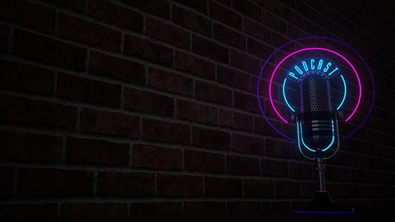 Ein Mikrofon mit einem Neon-Licht, das "Podcast" bildet, vor einer Backstein-Wand.