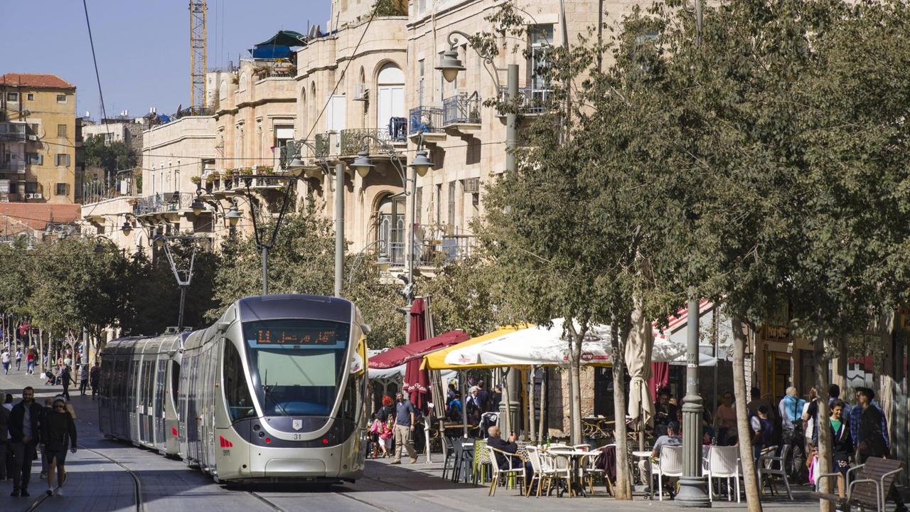 Das Foto zeigt die Yaffo Road in Jerusalem, durch die eine Straßenbahn fährt.