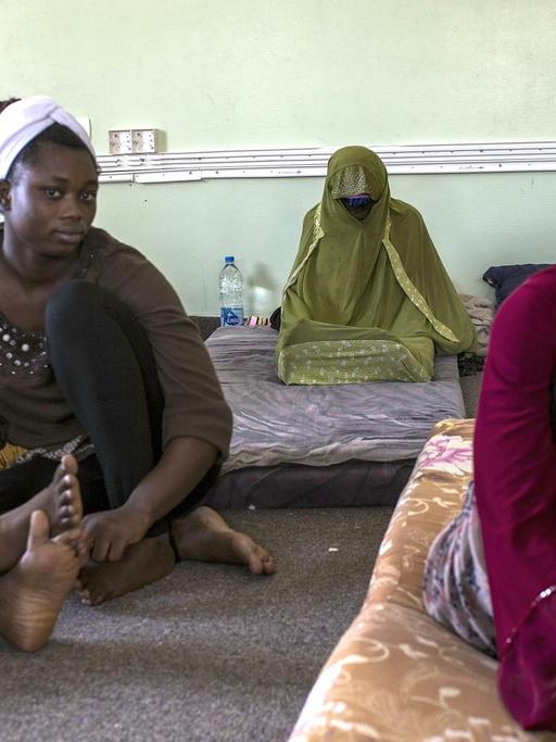 Nigerian women sit at Libya's Karareem detention centre near Misrata, a town half-way between Sirte and Tripoli, on September 25, 2016. Around 230 migrants, among them 15 women, mostly coming from sub-Saharan countries including Nigeria, Senegal, Chad, Mali, Sudan, Eritrea, Somalia and also Egypt and Bangladesh are detained in the centre. Some of the migrants arrived in Libya to look for a job, others to find a way to reach Europe. / AFP PHOTO / Fabio Bucciarelli