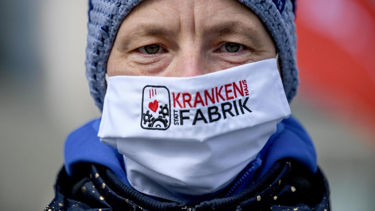 Eine Demonstrantin trägt einen Mundschutz mit der Aufschrift «Krankenhaus statt Krankenfabrik» vor dem Kanzleramt bei der Protestkundgebung von der Partei «Die Linke» im Rahmen der Kampagne «Menschen vor Profite: Pflegenotstand stoppen!».