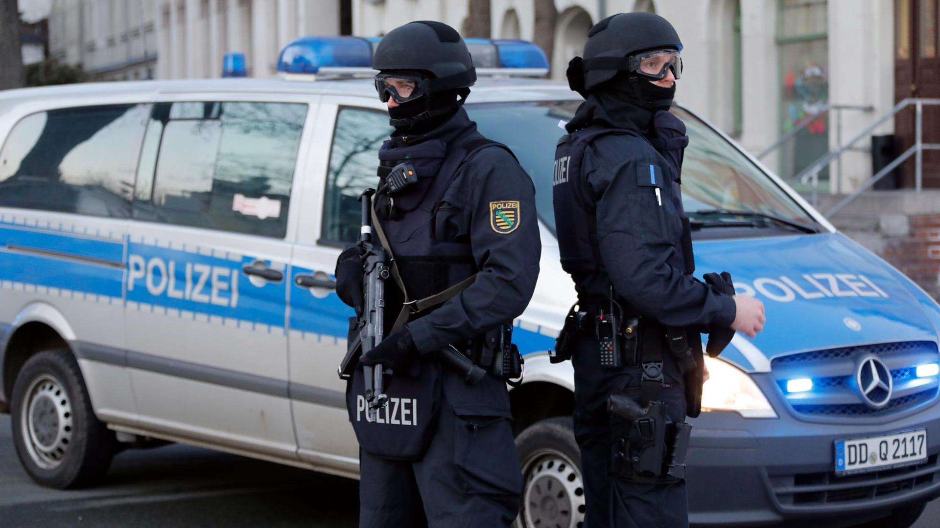 Polizisten stehen vor einem Mehrfamilienhaus in Chemnitz (Sachsen).
