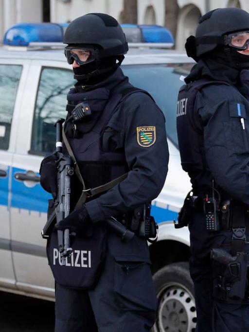 Polizisten stehen vor einem Mehrfamilienhaus in Chemnitz (Sachsen).