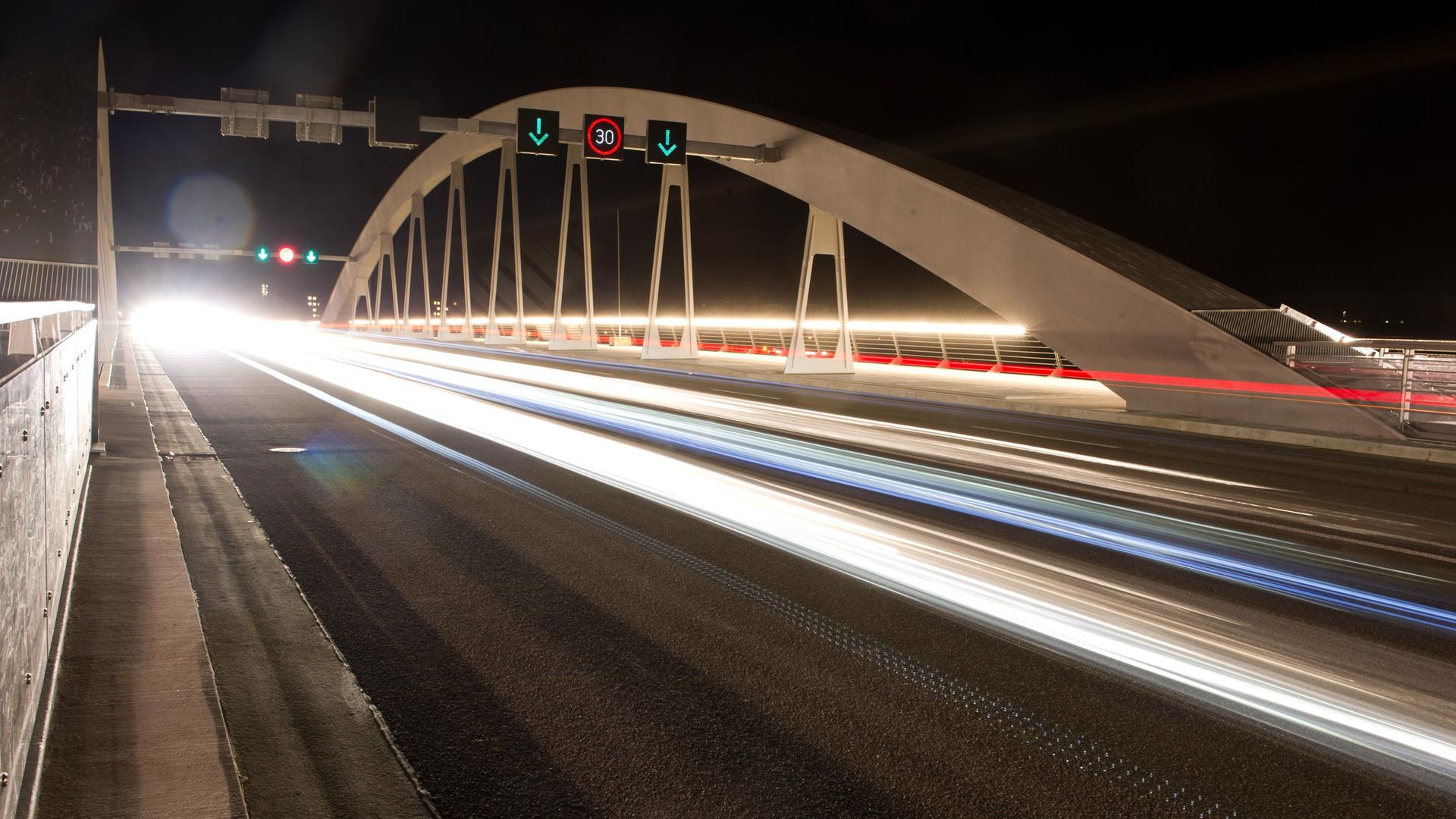 Autos fahren in den frühen Morgenstunden am 26.08.2013 über die Waldschlösschenbrücke in Dresden (Sachsen, Effekt durch Langzeitbelichtung). Die Brücke ist ab dem 26. August für den Verkehr freigegeben. Foto: Sebastian Kahnert/dpa