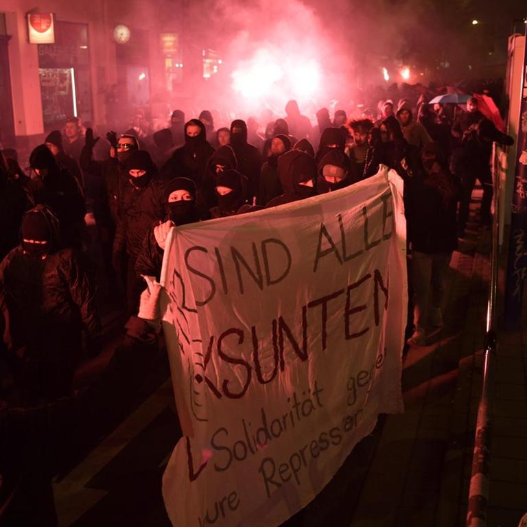 Auf dem Bild sind vermummte Demonstranten auf einer Straße in Leipzig zu sehen. Sie protestieren gegen das Verbot einer linksextremistischen Internetplattform 