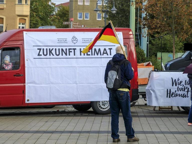 Teilnehmer einer Demonstration des mit der AfD verbundene Vereins "Zukunft Heimat" mit einer Deutschlandflagge