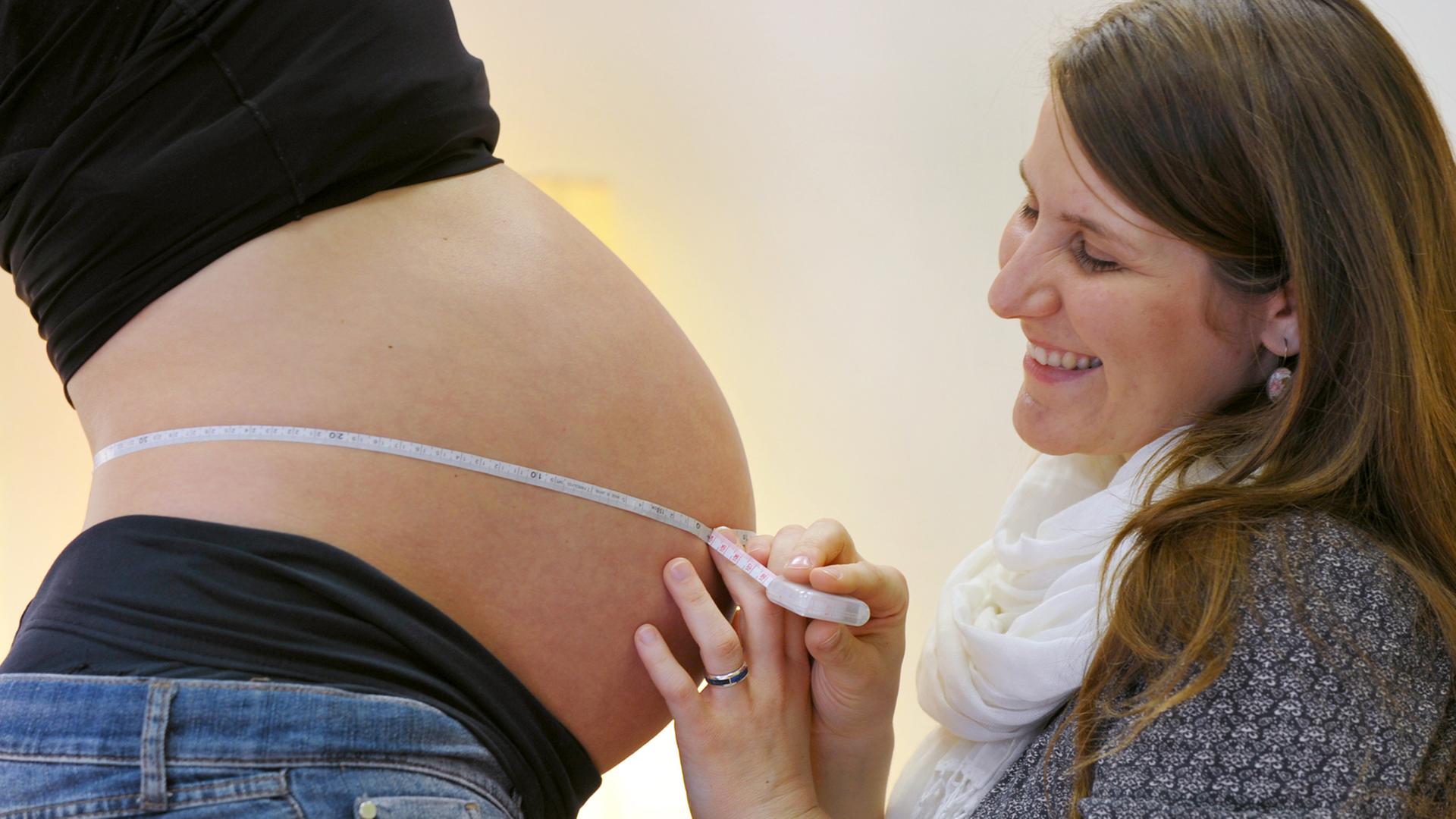 Eine Hebamme untersucht eine Schwangere