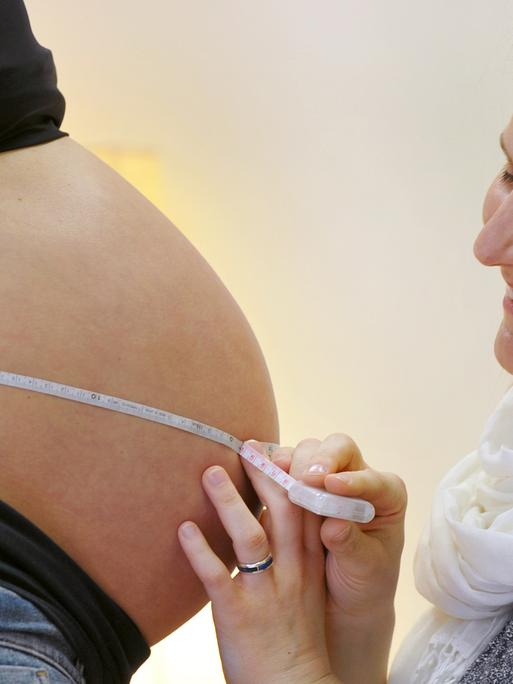 Eine Hebamme untersucht eine Schwangere