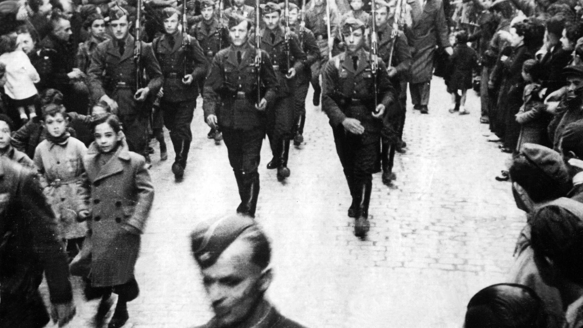 Einzug der Legion Condor in einer eroberte spanische Stadt. Die auf Seiten Francos eingesetzten deutschen Steitkräfte spielten bei den Kämpfen um Bilbao und Madrid eine entscheidende Rolle. Traurige Berühmtheit erlangte der Luftwaffenverband der Legion Condor durch die Vernichtung der nordspanischen Stadt Guernica.