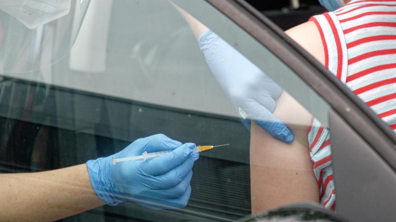 Ein Mitarbeiter spritzt bei einer Drive-in-Impfaktion eine Dosis Impfstoff von Johnson & Johnson in den Arm einer Frau, die in einem Auto sitzt. 