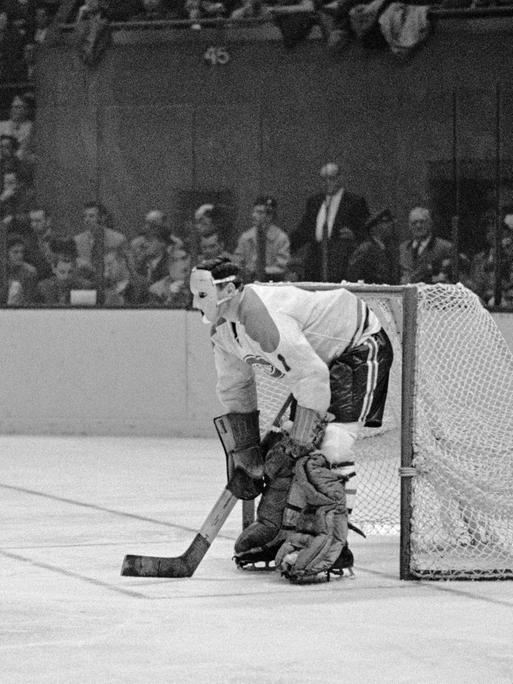 Jacques Plante, Star-Torwart der Montreal Canadiens mit einer Schutzmaske auf der Eisfläche vor dem Tor.