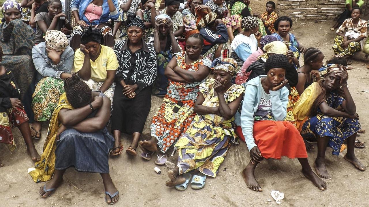 Zu sehen sind viele trauernde Menschen, die meisten Frauen, in einem Dorf im Osten des Kongo