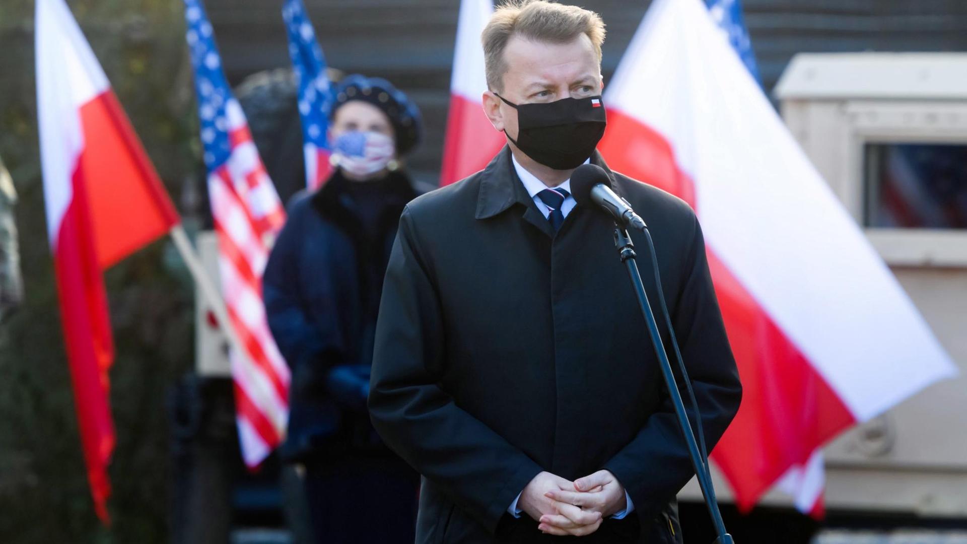 Polens Verteidigungsminister Mariusz Blaszczak steht mit Mundschutz vor einem Mikrofon Polens Verteidigungsminister Mariusz Blaszczak steht mit Mundschutz vor einem Mikrofon