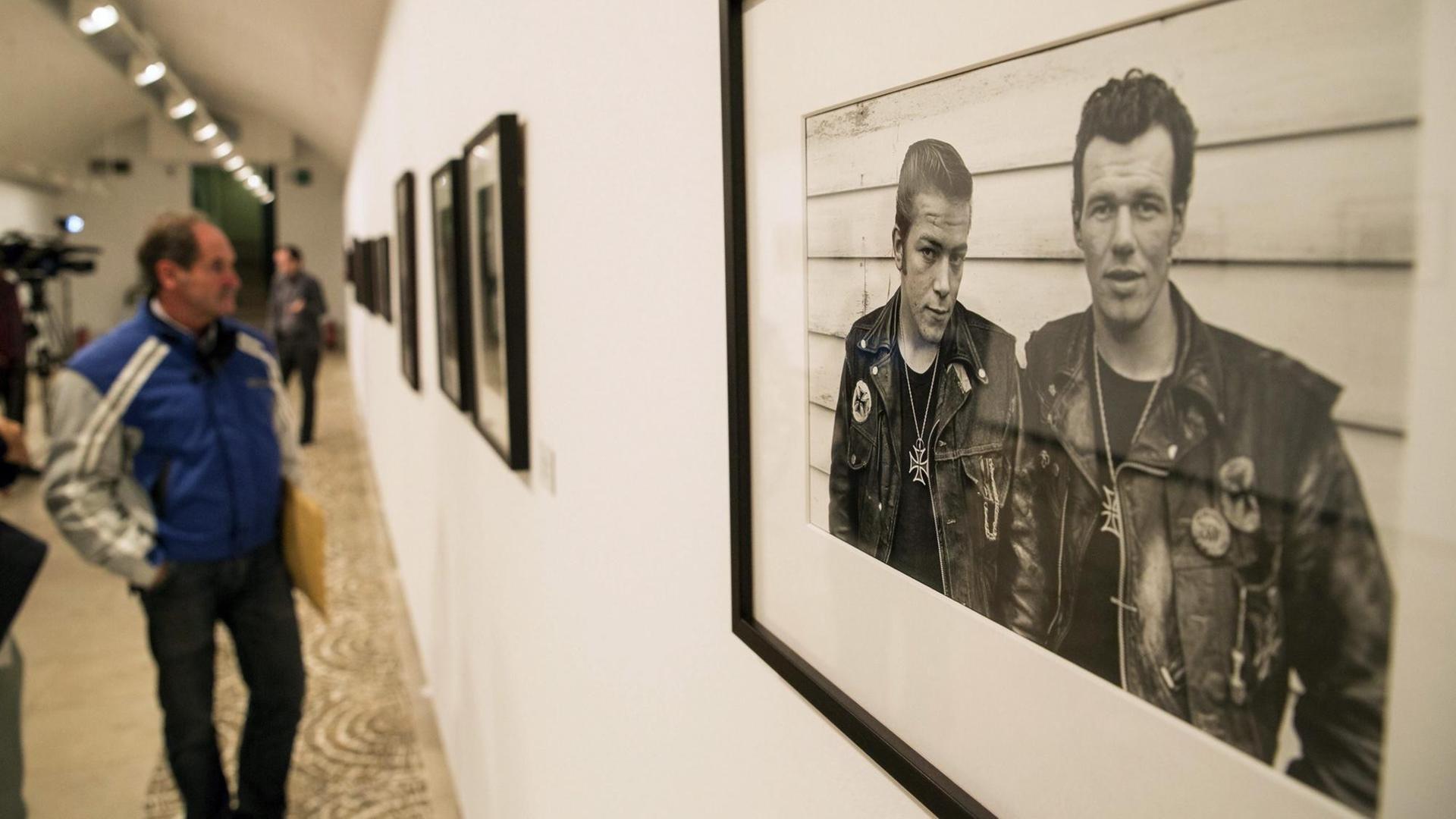 Ein Mann blickt in einer Ausstellung "The Bikeriders (1962-1966)" in Valladolid in Spanien auf ein Bild des US-Fotografen Danny Lyon.