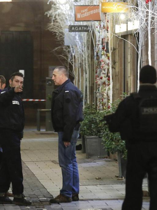 Französische Polizisten untersuchen den Tatort nahe dem Straßburger Weihnachtsmarkt.