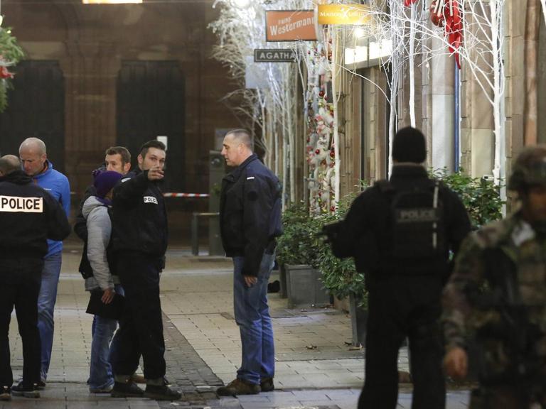 Französische Polizisten untersuchen den Tatort nahe dem Straßburger Weihnachtsmarkt.
